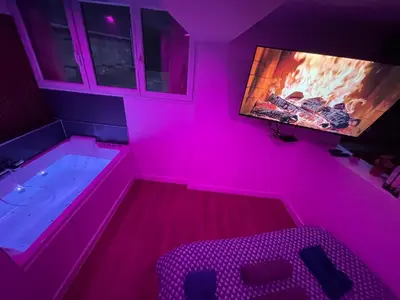 Télévision ou salle de divertissement dans l'établissement Nuit magique jacuzzi, terrasse & lit motorisé - 008