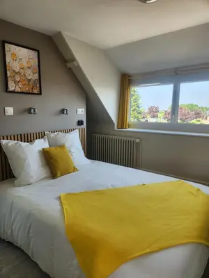 Un ou plusieurs lits dans un hébergement de l'établissement chambre jaune