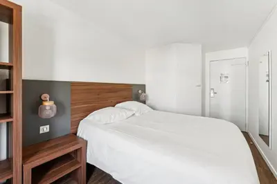 Un ou plusieurs lits dans un hébergement de l'établissement Hôtel Akena Pierrelaye
