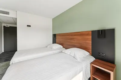 Un ou plusieurs lits dans un hébergement de l'établissement Hôtel Akena Pierrelaye