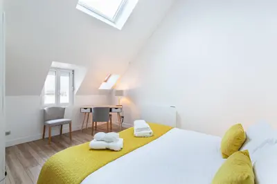 Un ou plusieurs lits dans un hébergement de l'établissement Suite Appart Place Versepuy