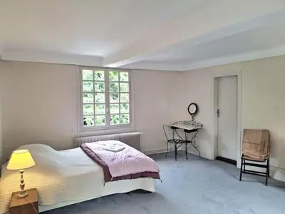Un ou plusieurs lits dans un hébergement de l'établissement Maison avec rivière et petit étang