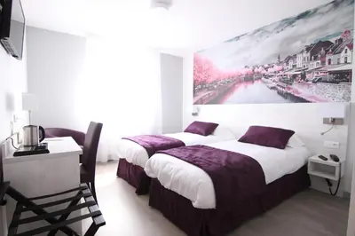 Un ou plusieurs lits dans un hébergement de l'établissement Logis Hôtel - La Chambre d'Amiens