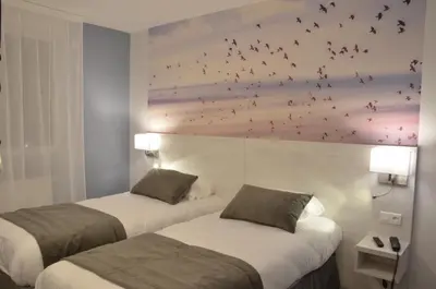 Un ou plusieurs lits dans un hébergement de l'établissement Logis Hôtel - La Chambre d'Amiens