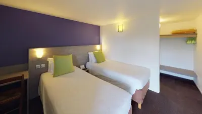 Un ou plusieurs lits dans un hébergement de l'établissement Kyriad Chantilly Sud - Luzarches