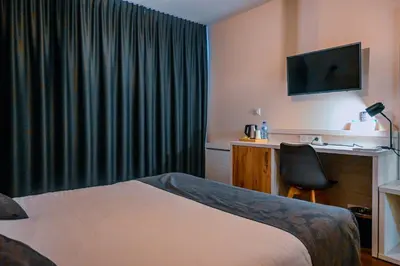 Un ou plusieurs lits dans un hébergement de l'établissement Logis Clermotel - Hôtel & Restaurant
