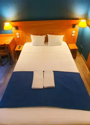 Un ou plusieurs lits dans un hébergement de l'établissement Glisy Hôtel