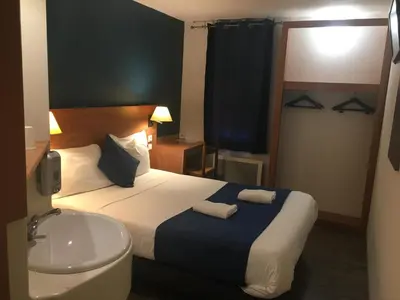 Un ou plusieurs lits dans un hébergement de l'établissement Glisy Hôtel