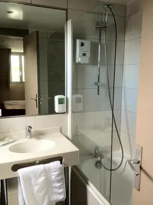 Salle de bains dans l'établissement LOGIS Hôtel & Restaurant - Les Arcades