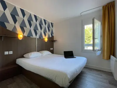 Un ou plusieurs lits dans un hébergement de l'établissement Kyriad Direct Val de Reuil
