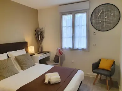 Un ou plusieurs lits dans un hébergement de l'établissement Hôtel et Chambres d'hôtes Les Mureaux - Les chambres de la Marina