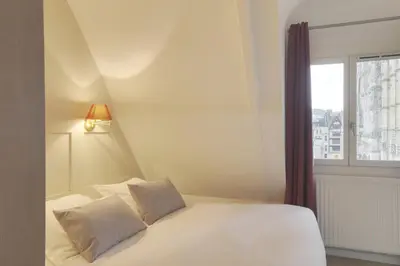 Un ou plusieurs lits dans un hébergement de l'établissement Hôtel Cardinal