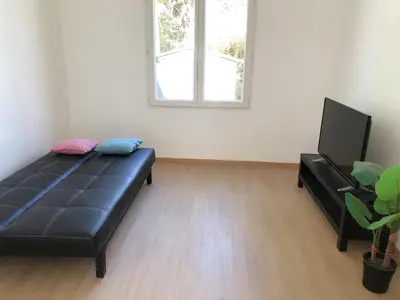 Télévision ou salle de divertissement dans l'établissement petite maison avec jardin dans banlieue de Paris
