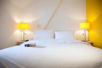 Un ou plusieurs lits dans un hébergement de l'établissement Logis Hôtel La Ruche